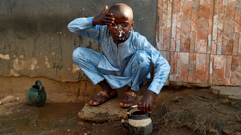 One boy dey perform di ritual ablutions before im pray for one mosque to celebrate Eid al-Fitr for inside mosque in Kara Ibafo in Ogun State, on May 24, 2020.