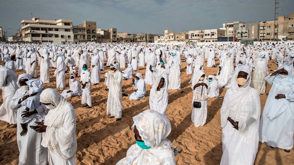 Followers of the Layene community wearing protective masks take place on the beach in front of the Yoff Layene Mosque, during the Islamic festivity of Korite in Dakar, Senegal, on May 24, 2020,