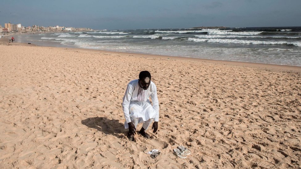 One member of the Layene community dey pray for di beach during eid