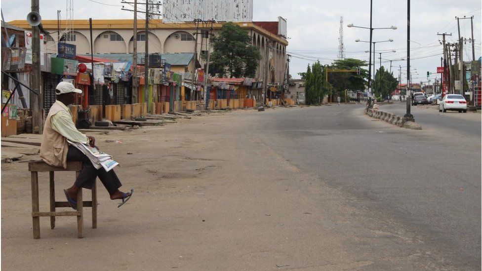 Newspaper vendor siddon for empty street for Lagos during lockdown for March, 20202