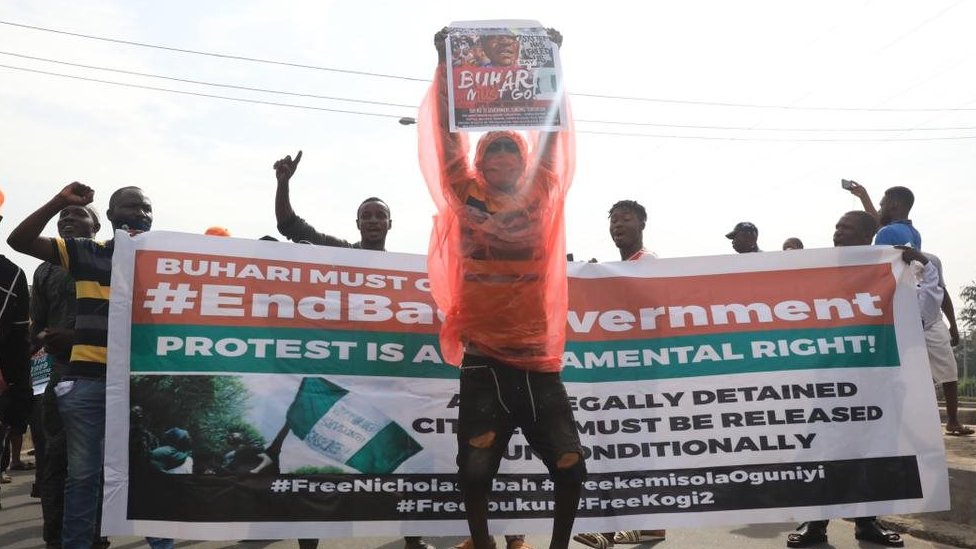 Protester carry placard in front of banner on June 12, 2021 for Lagos