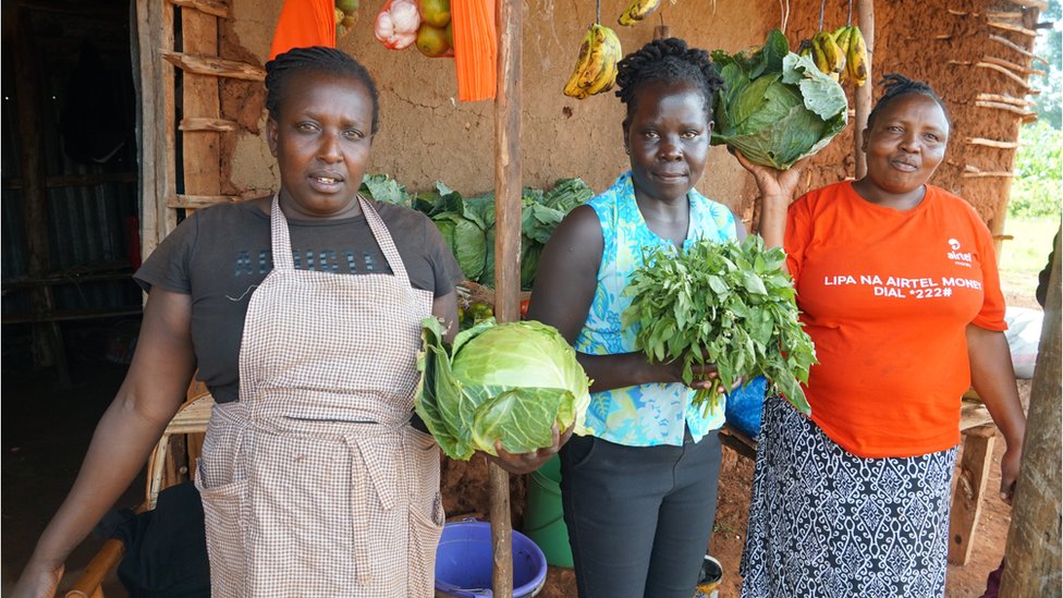 Mama Sasha and her friends showcase cabbages outside her stall for Kosachei