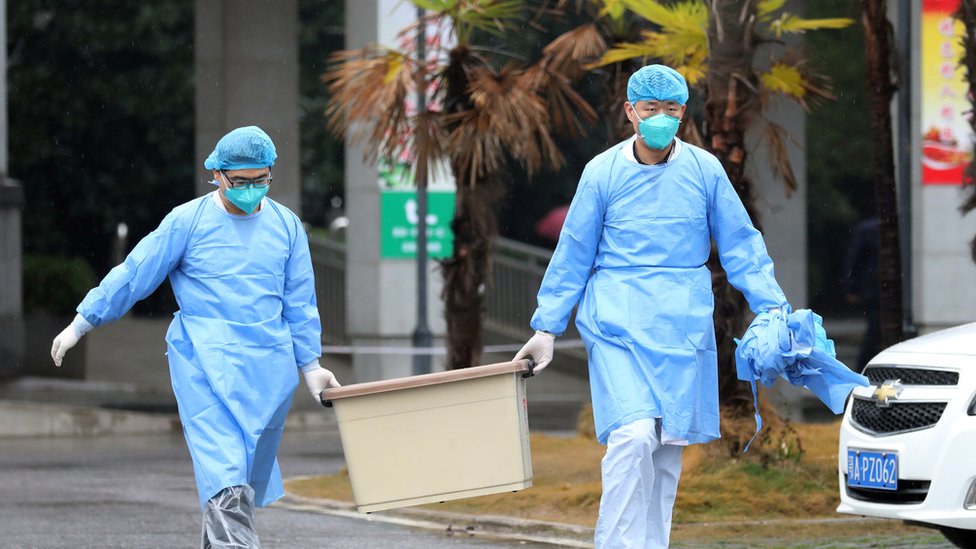 Medical staff carry a box as they walk at the Jinyintan hospital, where the patients with pneumonia caused by the new strain of coronavirus are being treated, in Wuhan