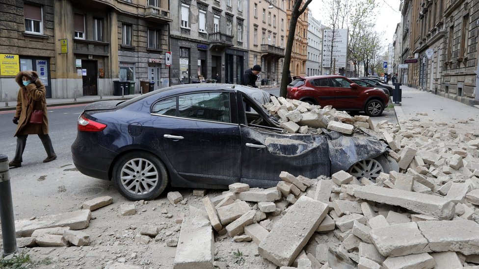 A person walks past rubbles lying on a street after a 5.3-magnitude earthquake that hit near Zagreb, Croatia, 22 March 2020