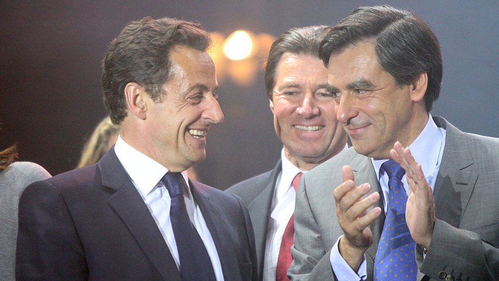 Nicolas Sarkozy, left, dey laugh ontop stage alongside Francois Fillon