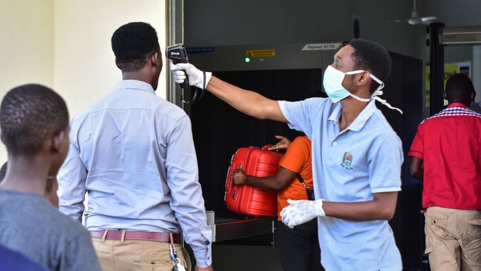 One worker dey check di temperature of travellers for di border post with Kenya for Namanga, northern Tanzania, on March 16, 2020, on di day Tanzania confam im first case of Covid-19.