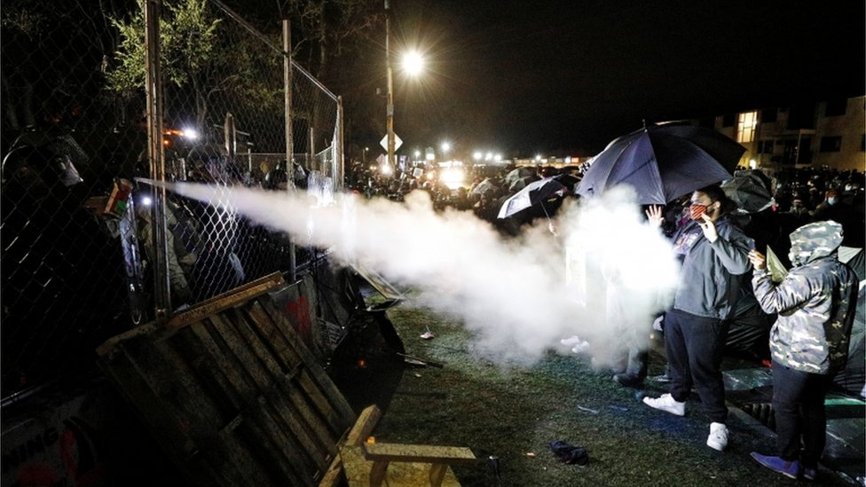 Pepper spray is used from behind the fenced up perimeters of the Brooklyn Center Police Department. 14 April 2021