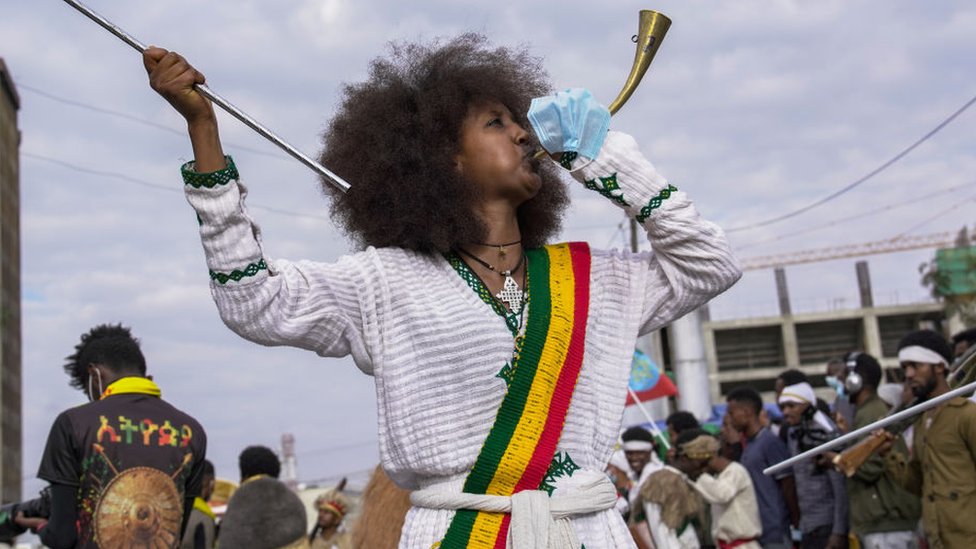 One woman blow one trumpet ahead of one procession to mark di victory for di Battle of Adwa - March 2021, Addis Ababa, Ethiopia