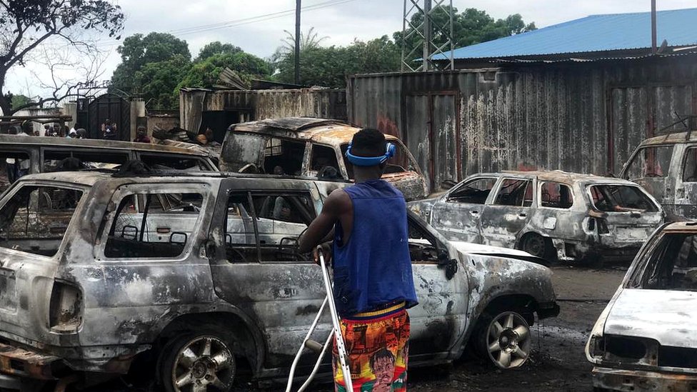 Passer-by dey look di burnt vehicles for di tanker explosion