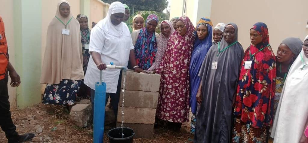 Women pose wit running water for Gbata