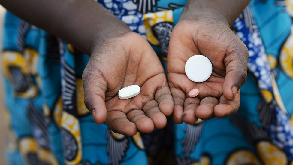 A child holding medicine in her hands