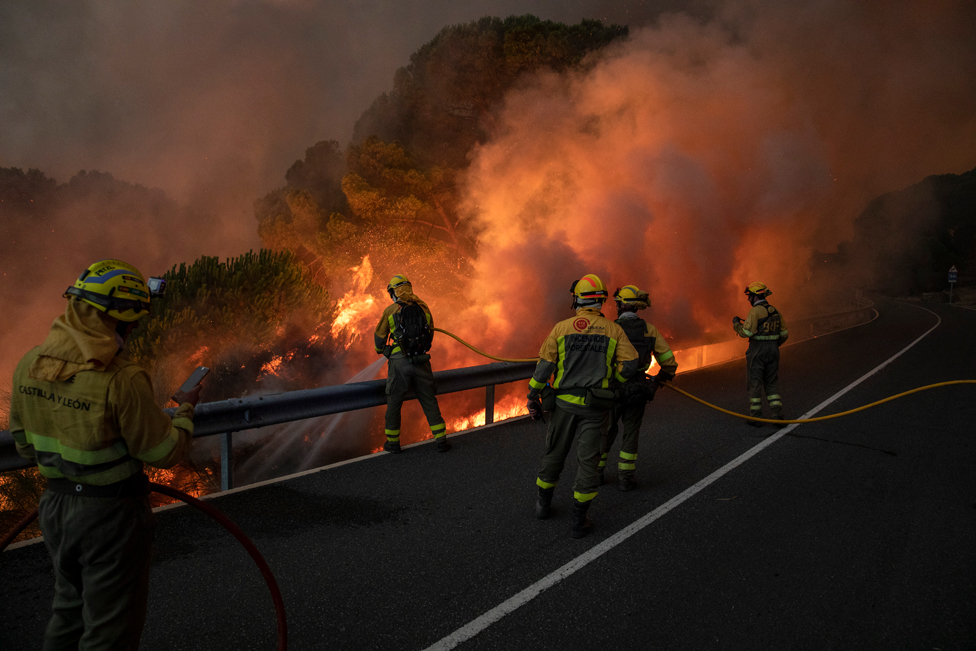 Firefighters from the Brigadas de Refuerzo en Incendios Forestales (BRIF) tackle a forest fire approaching to houses at El Hoyo de Pinares on July 18, 2022 in Avila, Spain.