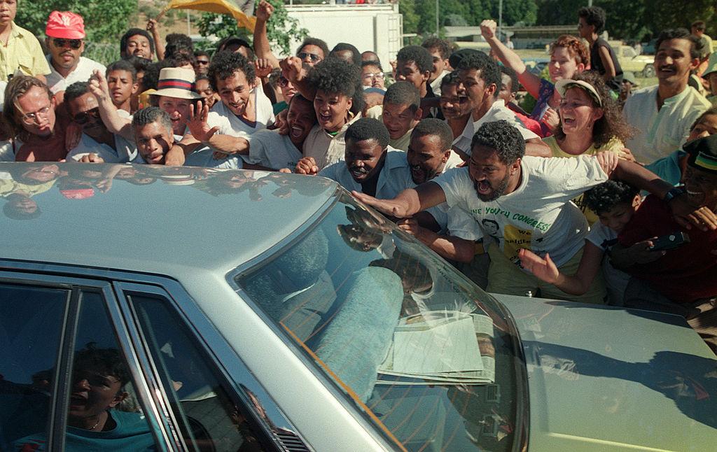 Nelson Mandela ride inside car through cheering fans as e leave from Victor Verster prison afta dem release am, 11 February 1990.