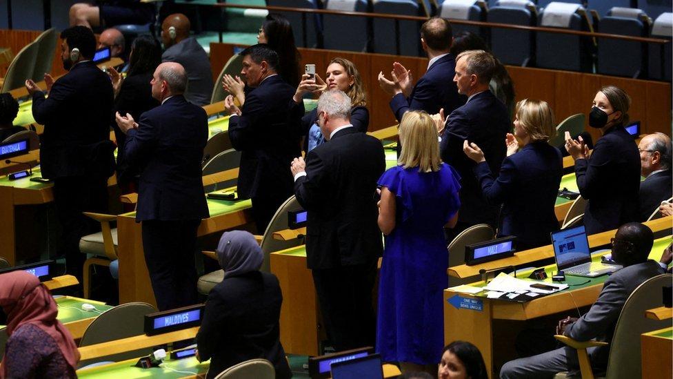 UN delegates stand to clap for President Zelensky video address