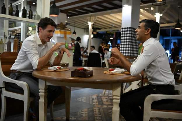 Canada Justin Trudeau (L) and UK Rishi Sunak dey chat for cafe afta dem land for Bali 