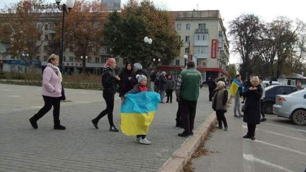 G﻿irl hold Ukraine flag to celebrate for Kherson