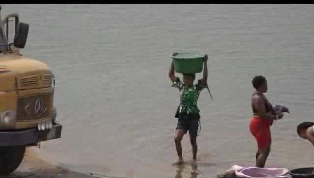 Woman dey fetch water from di Cross river