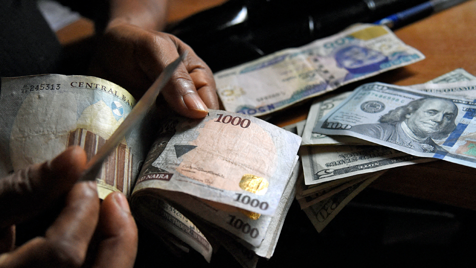 One man exchange Nigeria currency naira for US dollars for Lagos, Nigeria - April 2021