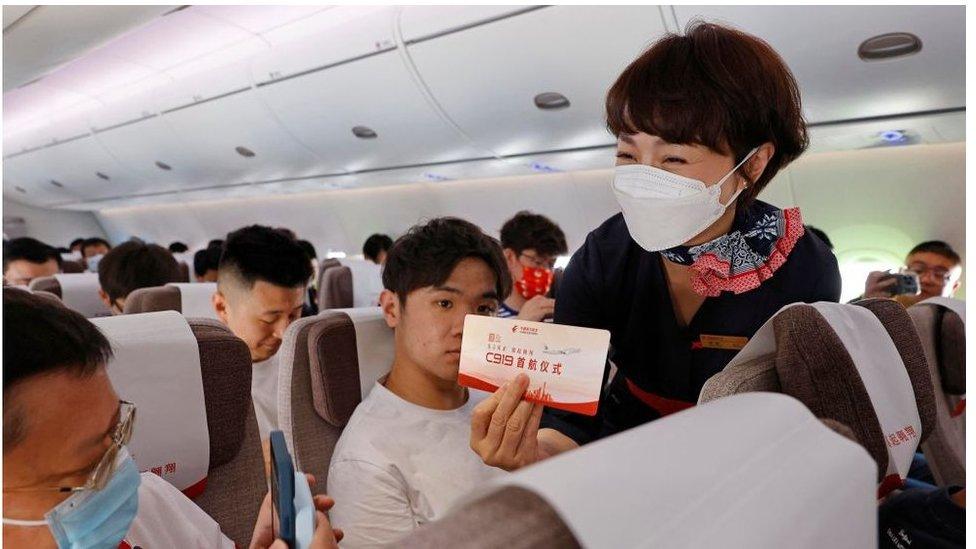 Air hostess handout special red boarding pass during di first commercial flight of di C919 plane