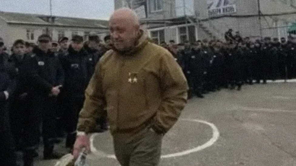 Wagner leader Yevgeny Prigozhin waka pass a line line of prisoners