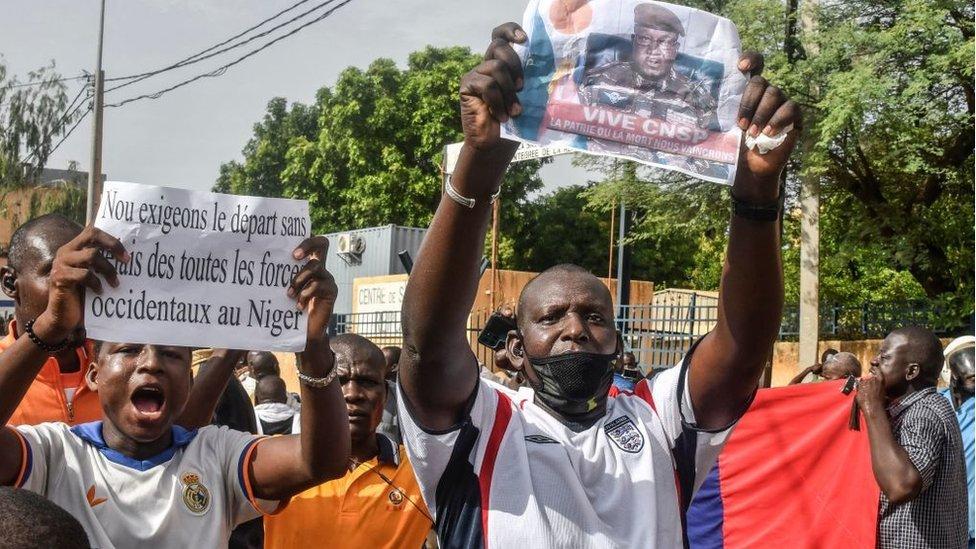 One supporter hold one foto of Niger General Abdourahamane Tiani, the chief of the powerful presidential guard, as with others rally in support of Niger junta for Niamey on July 30, 2023