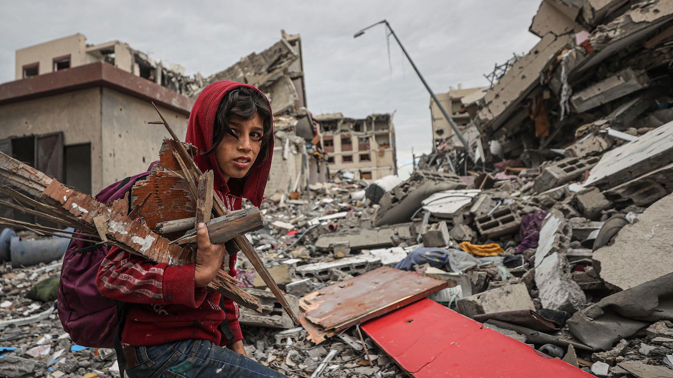 One boy collect firewood inside destroyed buildings for Gaza