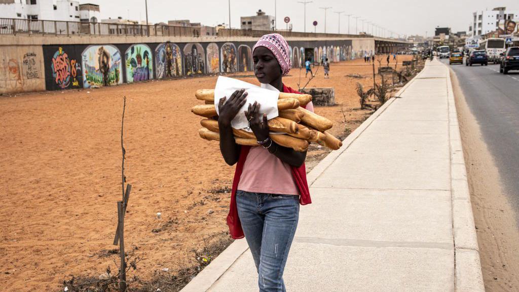 Woman carry bread for road for Dakar, Senegal - February 2024