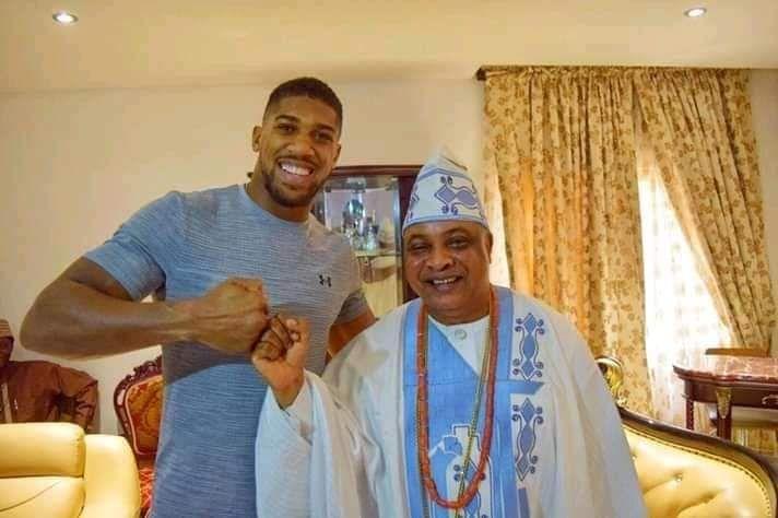 Anthony Joshua smile as e bump fists wit one dignitary wey wear traditional Nigerian cloth for di town of Sagamu