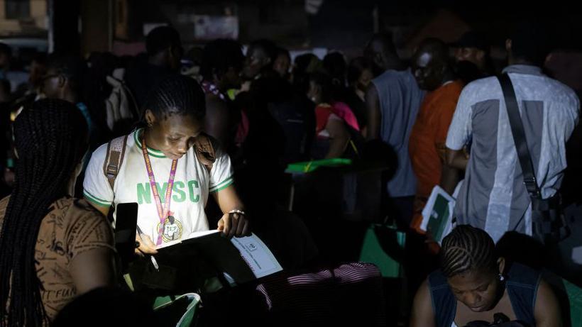 A member of the National Youth Service Corps (NYSC) checks electoral materials before returning them to the INEC offices in Amawbia, Awka, on February 25, 2023, during Nigeria's presidential and general elections. 