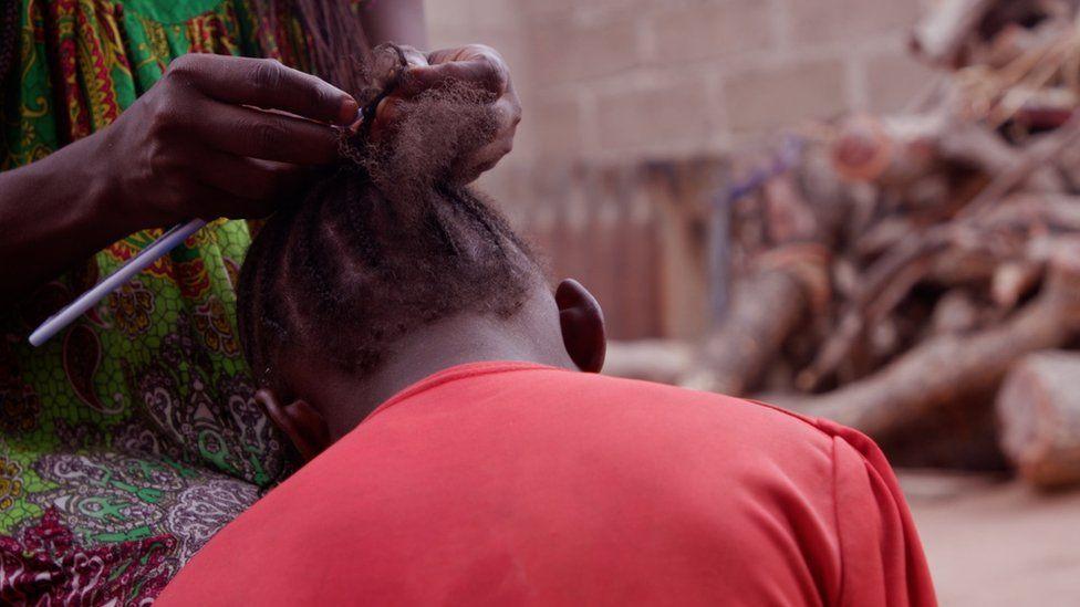 Young girl having her hair braided