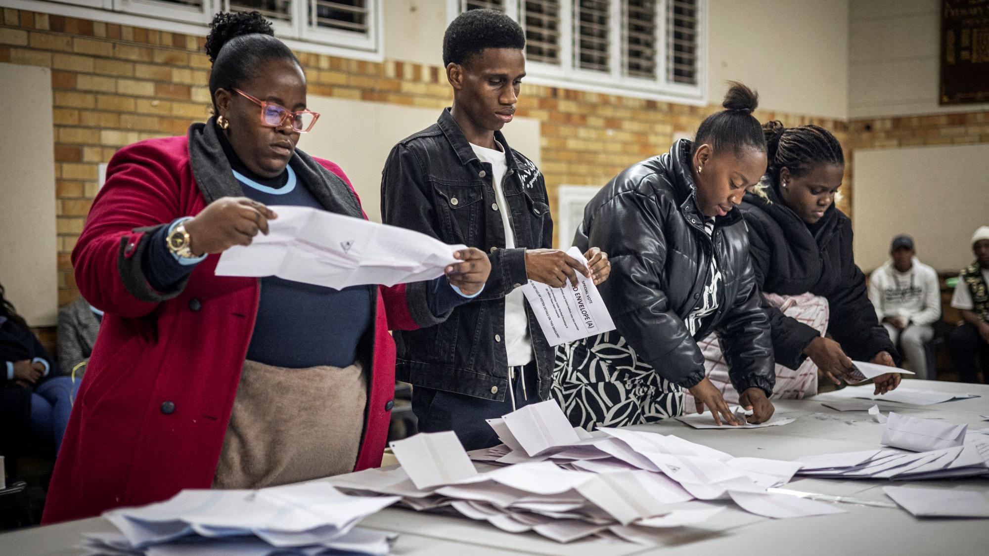 A woman holding a ballot paper as Independent Electoral Commission (IEC) count ballots at the Craighall Primary School polling station in Johannesburg on May 29, 2024, during South Africa's general election.