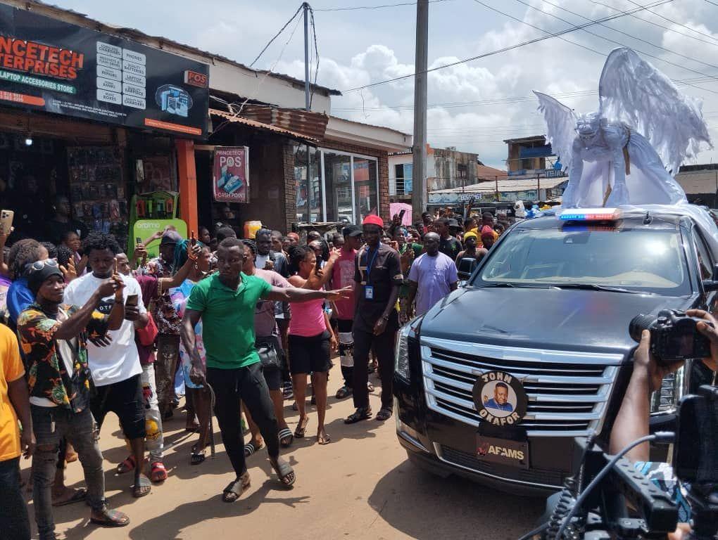 Crowd gather dey watch vehicles wey dey pass during di burial of late Mr Ibu