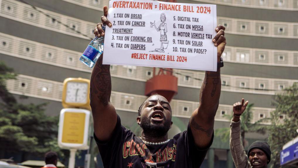 A protester holds up a sign during a demonstration against the proposed government tax bill in the Central Business District of Nairobi, Kenya, on Tuesday, June 25, 2024