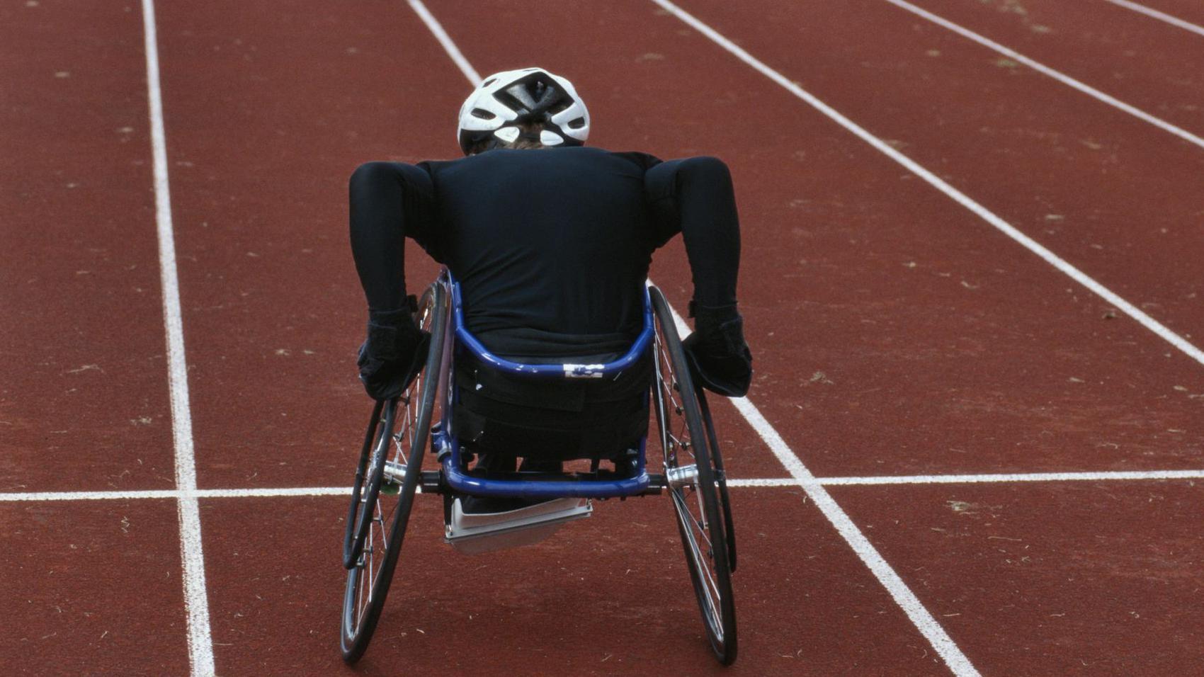 Young male wheelchair track athlete on track