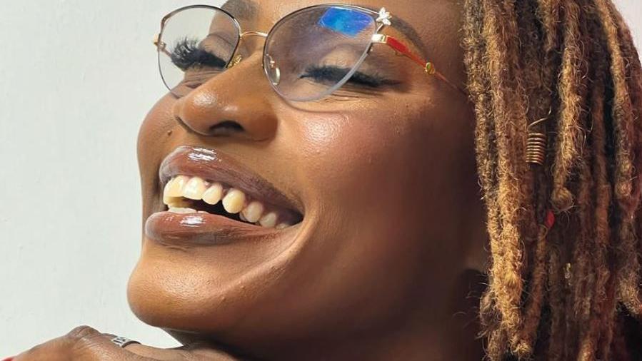 Very tight close up of smiling Udoh Ebaide Joy. She is wearing specs