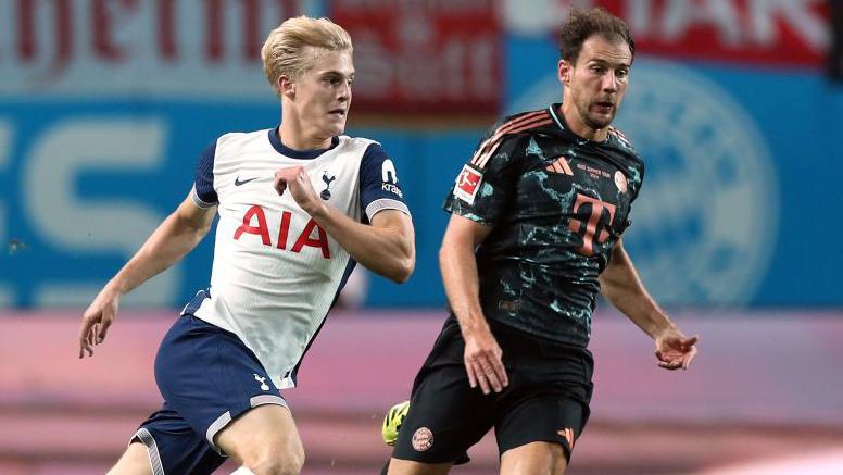 Lucas Bergvall of Tottenham battles for the ball with Leon Goretzka of Bayern Munich