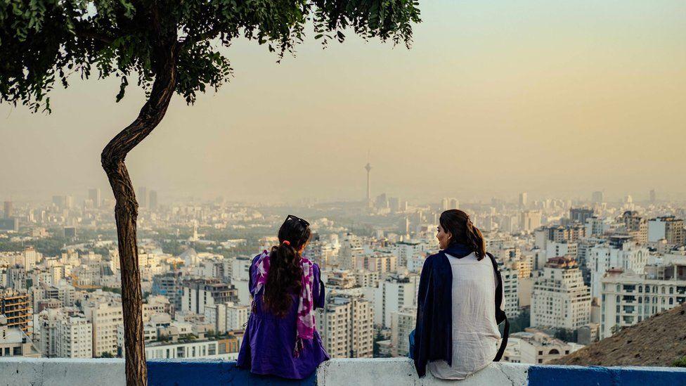  Iranian women wey no dey follow di compulsory hijab siddon for Bam-e Tehran (Roof of Tehran) overlooking di city of Tehran, 2024