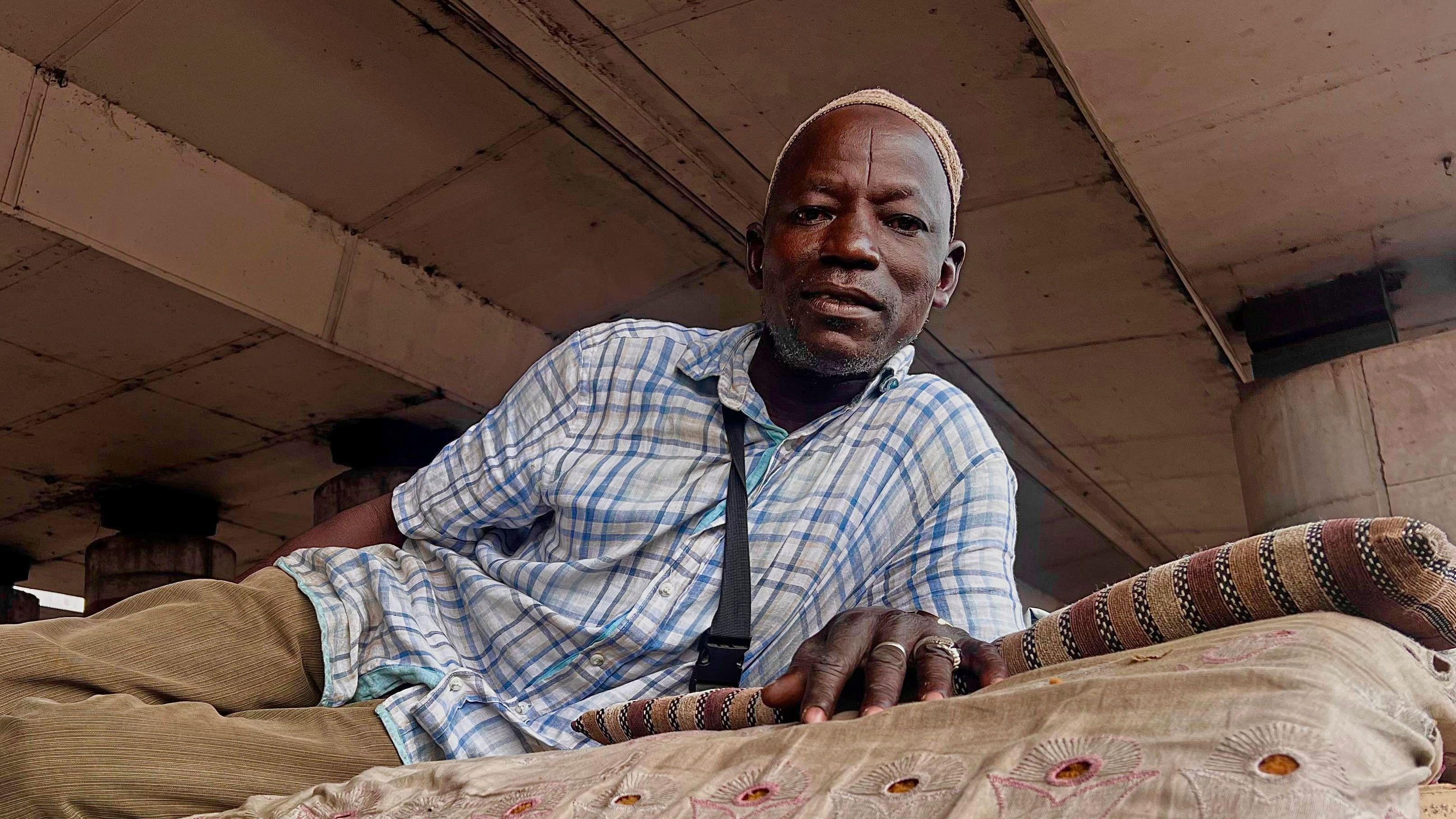  Liya’u Sa’adu dey lie doen on im mattress under bridge in Lagos, Nigeria