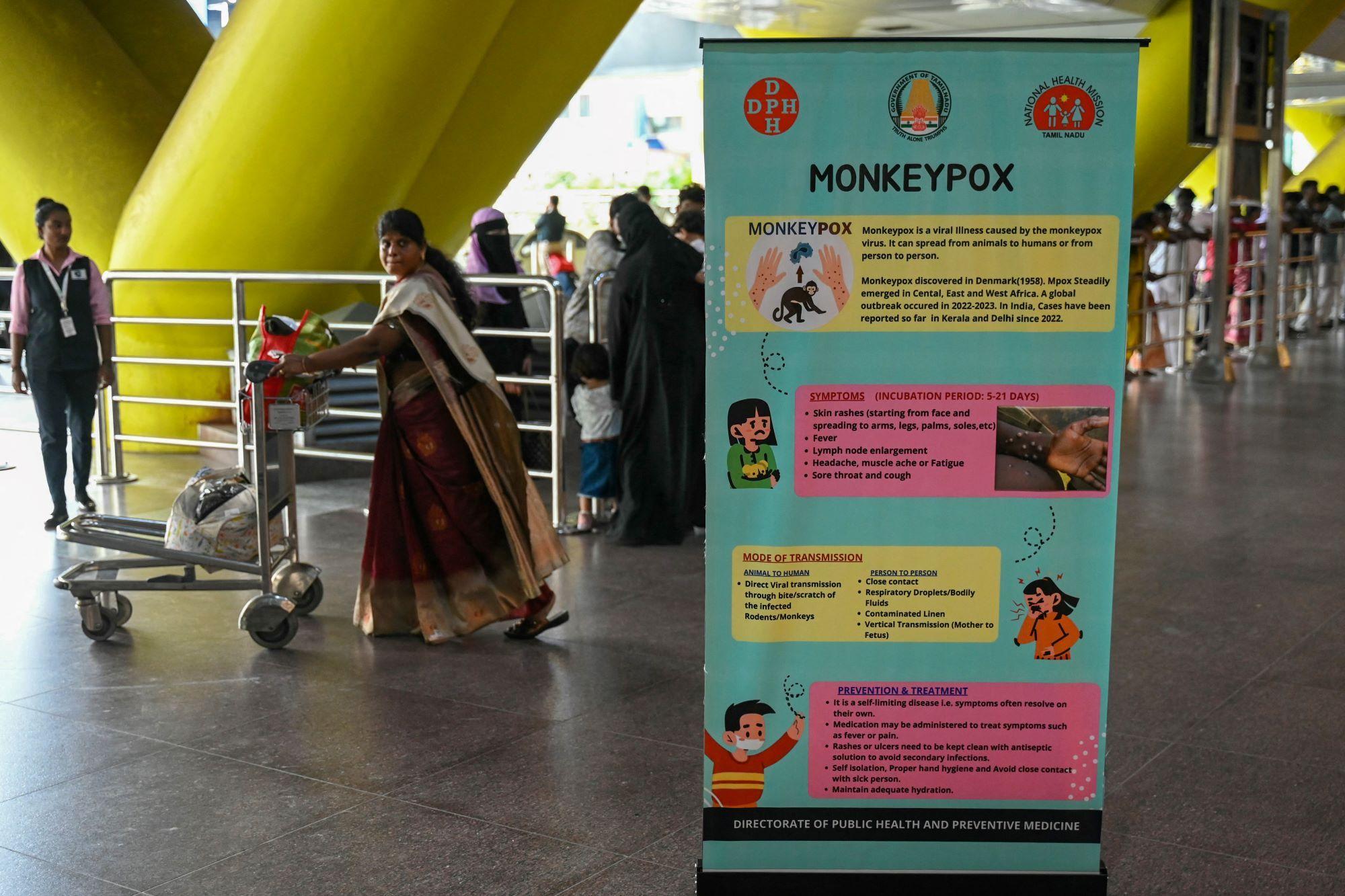 Passengers walk past the mpox awareness banner at Anna International Airport terminal in Chennai on August 21, 2024. (The WHO began phasing out "monkeypox" and the introduction of "mpox" in November 2022 - the phase-out was completed in November 2023.)