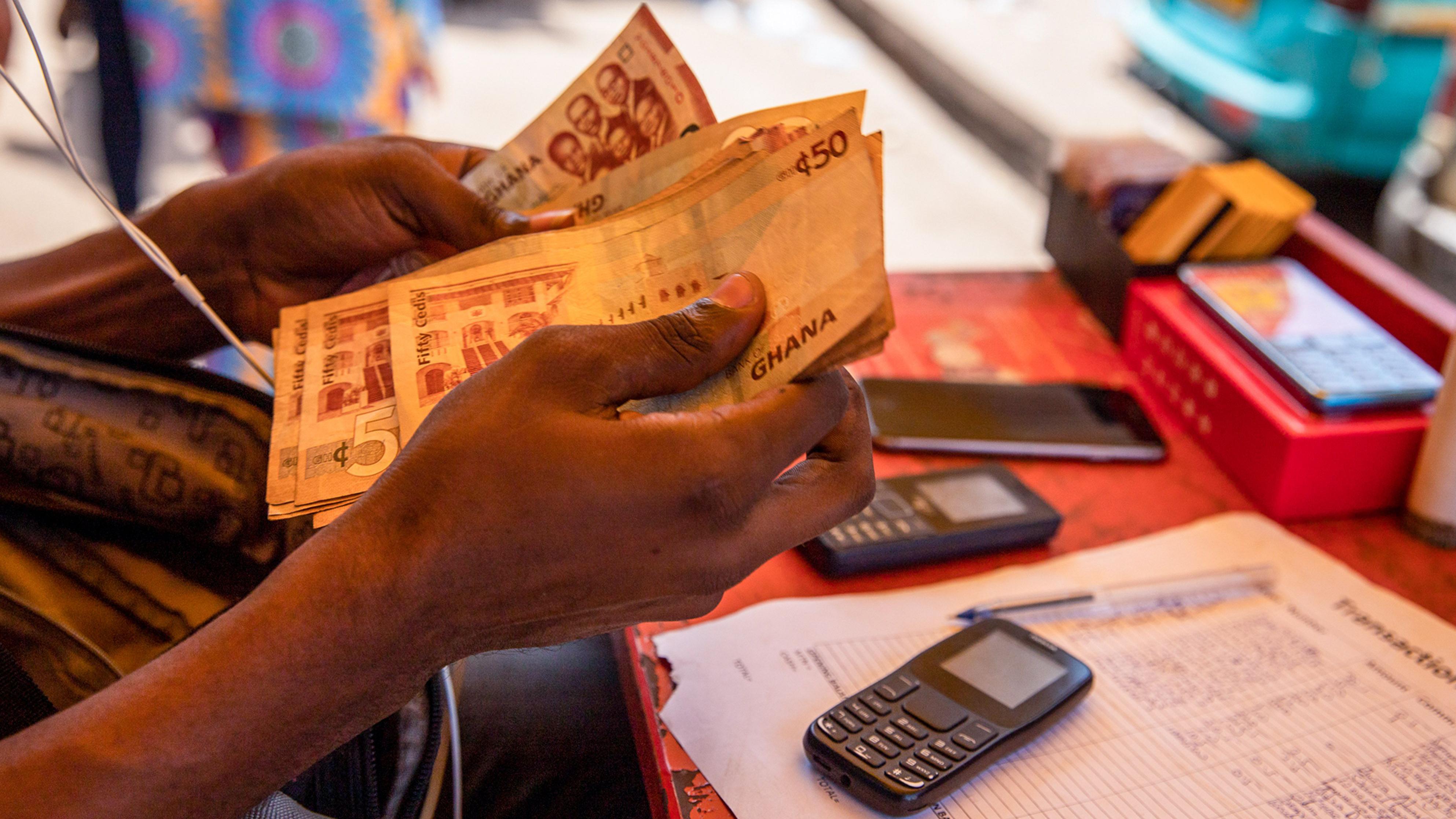 Money being counted after customer withdrew from mobile money vendor