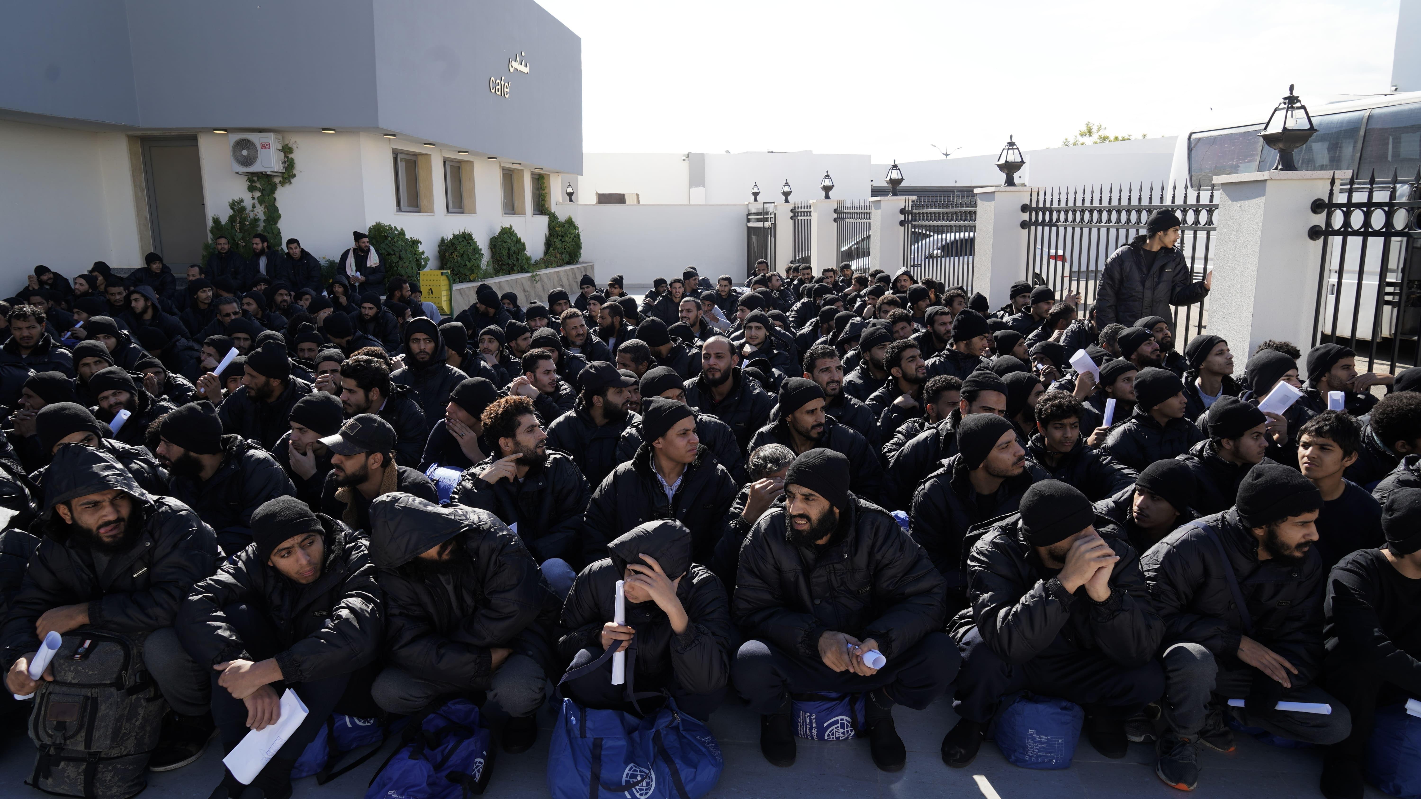 Hundreds of migrants wait at a repatriation centre before they are sent to Tripoli