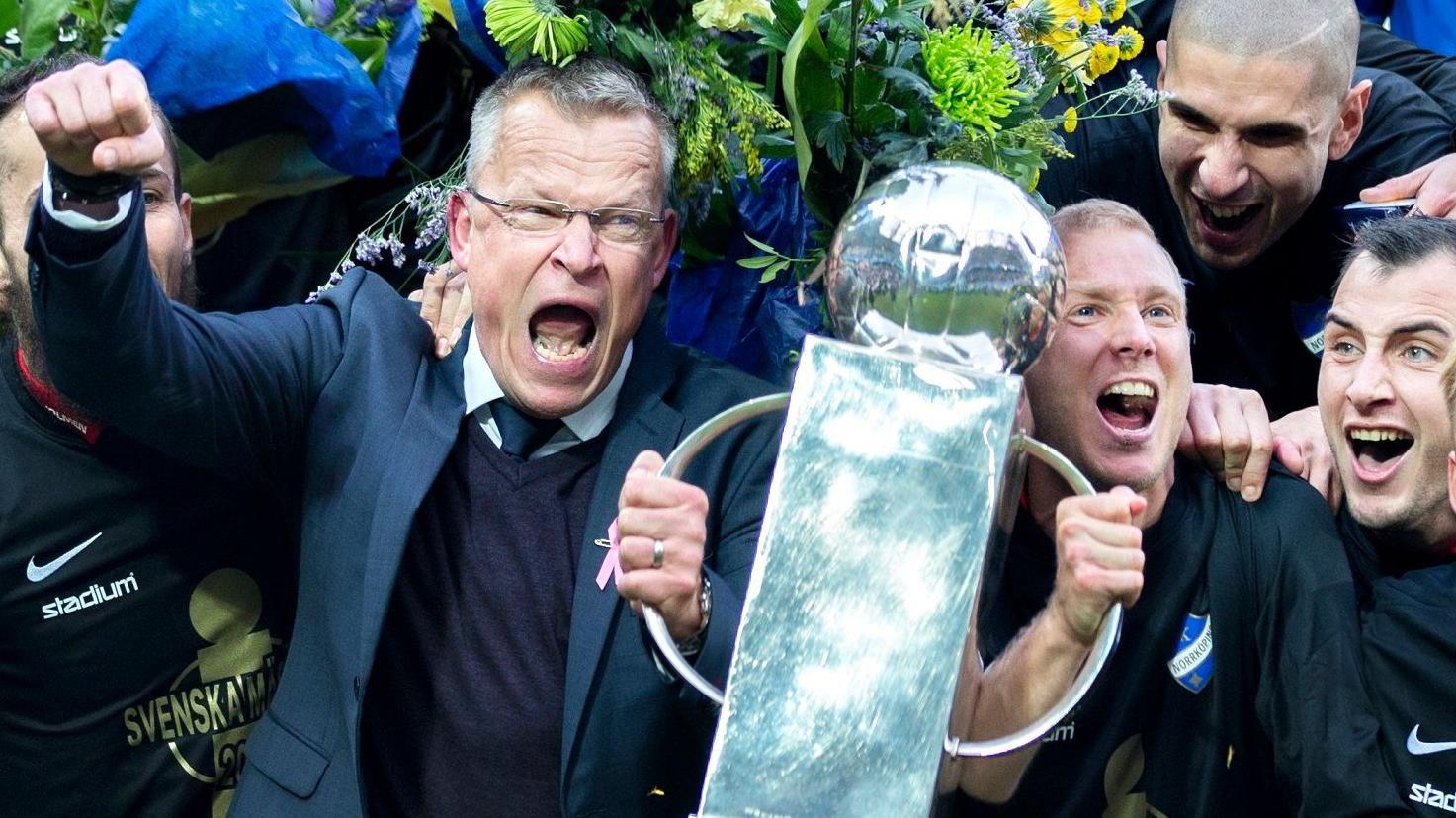 Janne Andersson screams for joy as im hold one handle of di Allsvenskan trophy