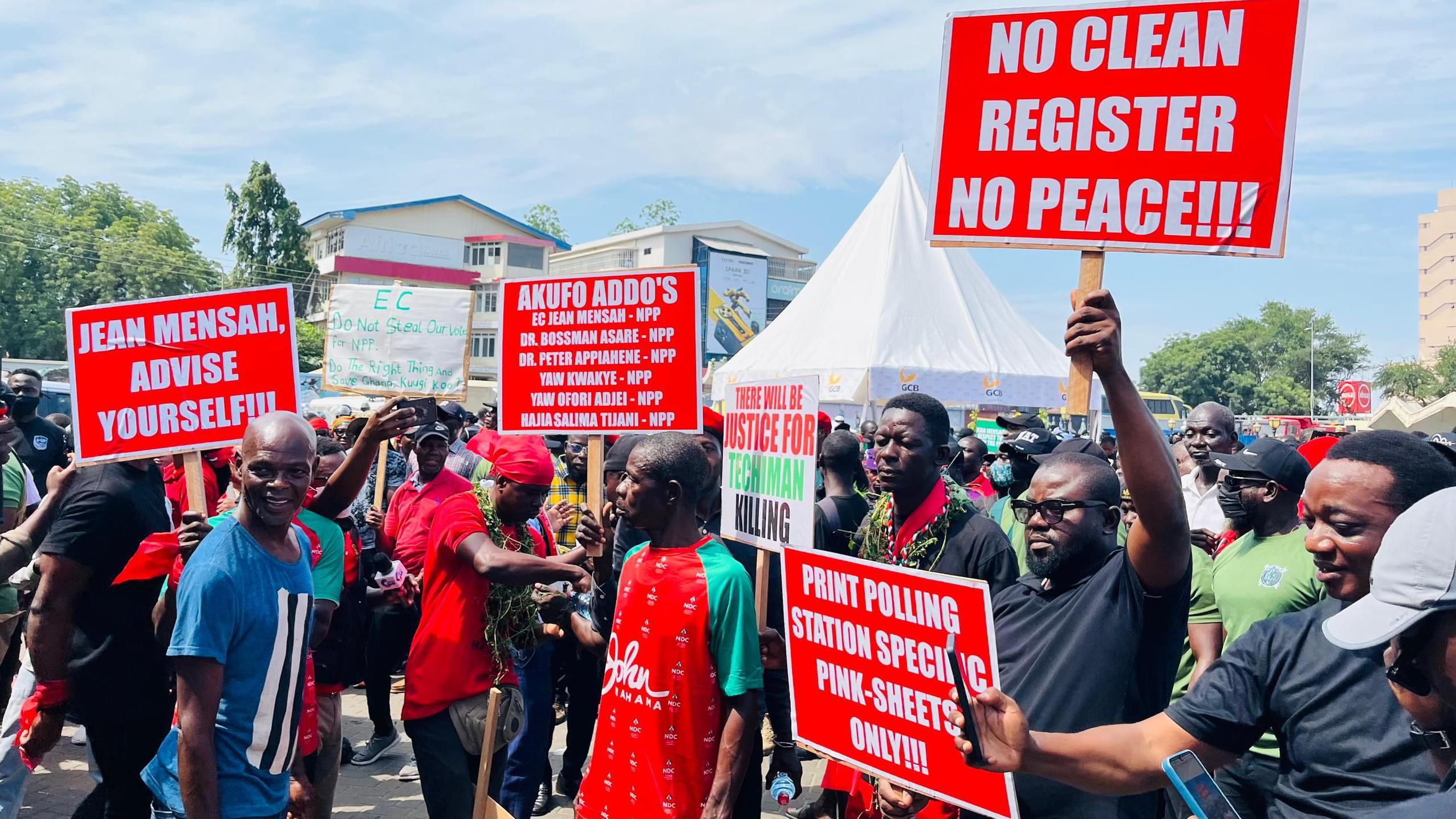 Protesters carry placards