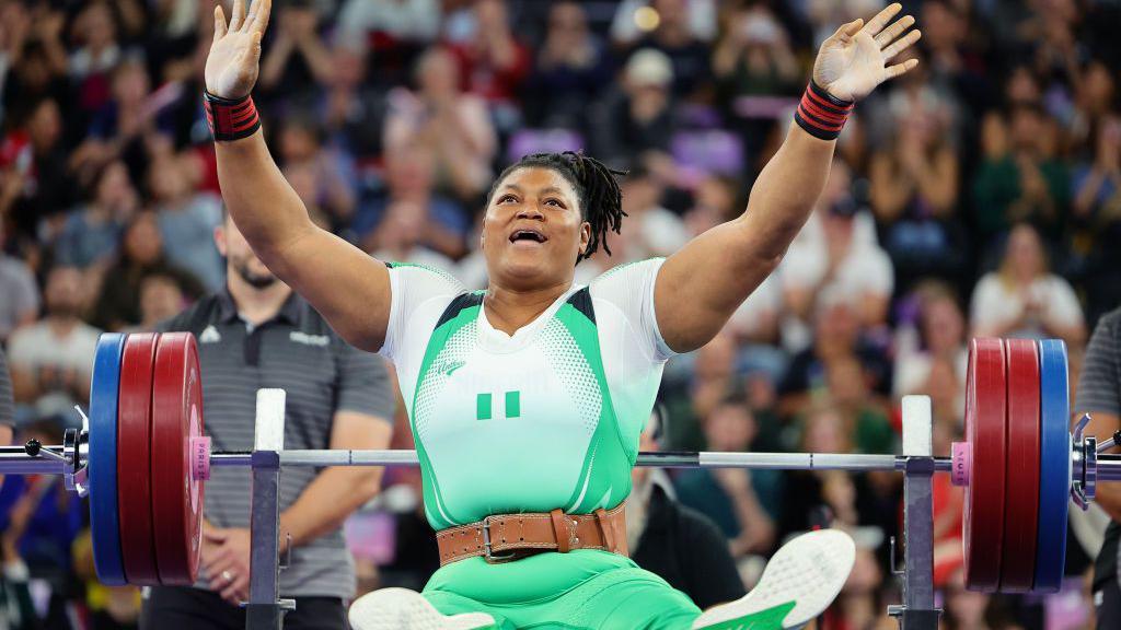 Nigeria powerlifter lift her hand for up afta she lift di ova 86kg at di 2024 Paralympics