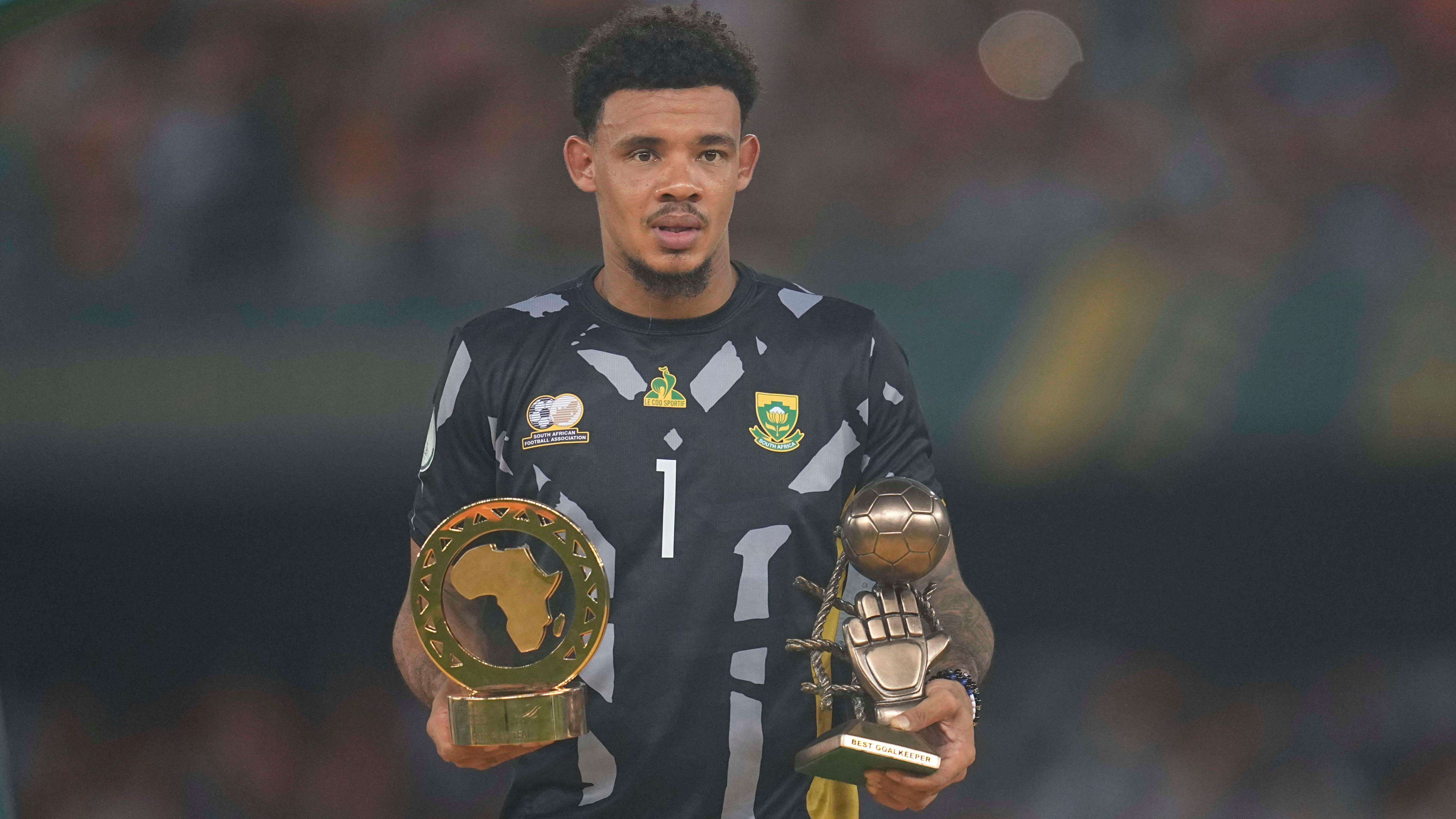 Ronwen Williams, wearing a black goalkeeping shirt, holds the Fair Play and Best Goalkeeper awards from the 2023 Africa Cup of Nations finals