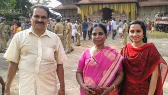 Dr Vasu stand in front of a temple