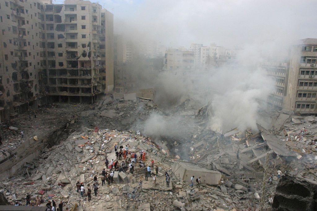 Rescue workers search in the rubble of a building complex hit in an Israeli strike in the heart of the Shia-dominated suburbs of Beirut on 13 August 2006 (AFP via Getty Images)