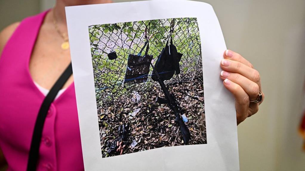 Palm Beach County Sheriff PIO Teri Barber hold photographs of di rifle and oda items dem find near wia dem discover di suspect during press conference regarding di assassination attempt of former President Donald Trump on September 15, 2024, for West Palm Beach, Florida.