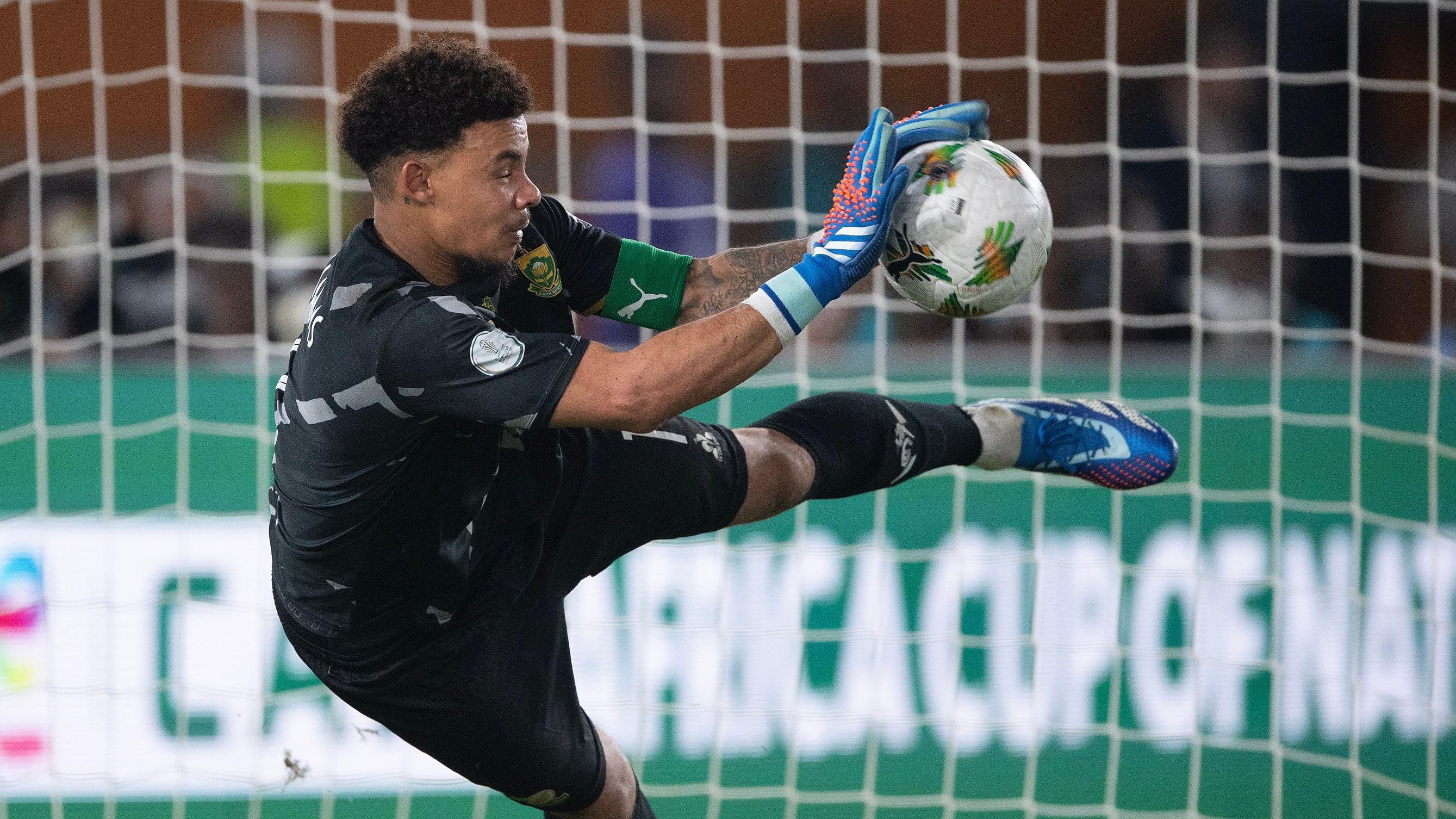 Ronwen Williams dives to his right to palm away football during penalty shootout at the 2023 Africa Cup of Nations