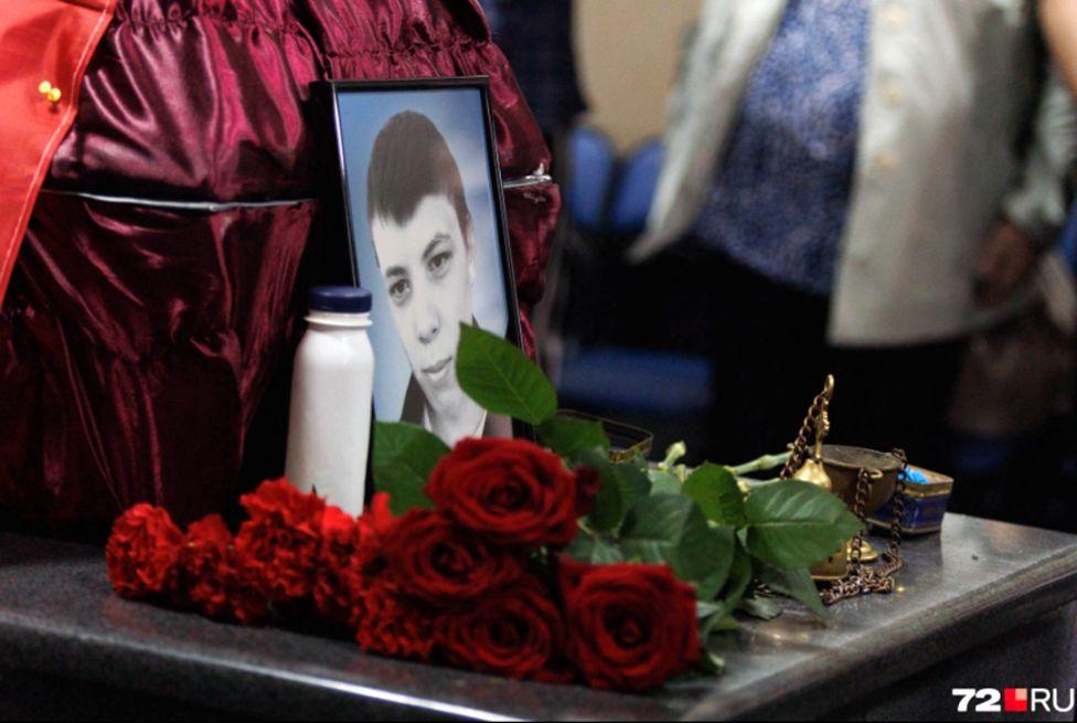 A close up of  a photo of Lipavsky and some roses next to his coffin